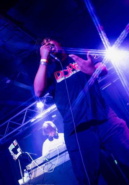 Halloween Riot — artist on the mic with stage lights flaring