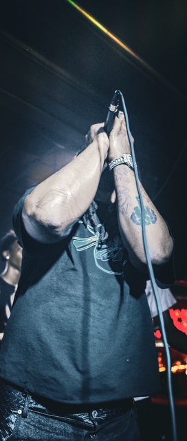Halloween Riot — performer gripping the mic stand under blue light